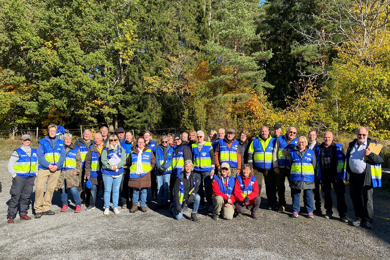 40-tal personer i blå/gula västar, gruppbild.