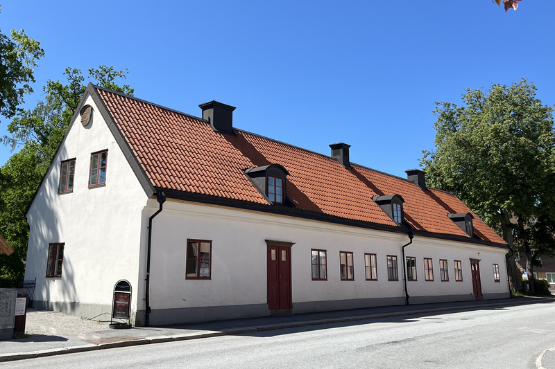 Roslagsmuseet är en vit avlång byggnad med rött tegeltak