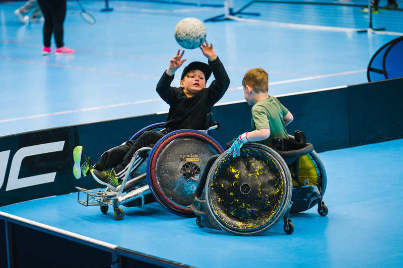 Två pojkar i rullstol spelar boll 