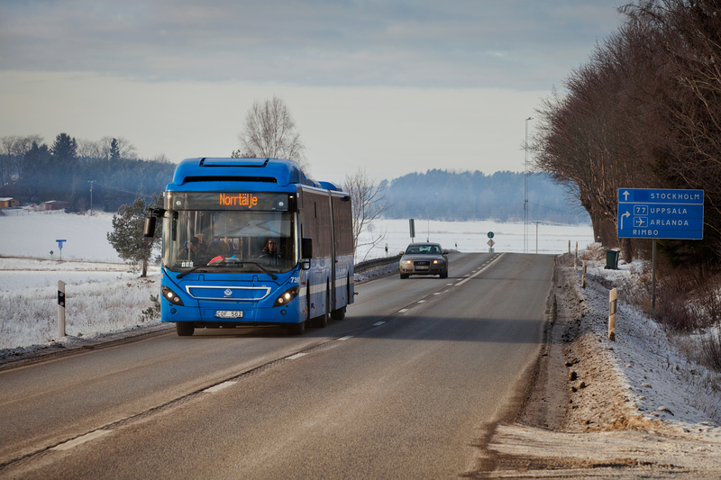 Bild som visar en blå buss med texten norrtälje på. Snöigt landskap