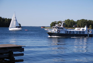 Bild som föresrtäller två båtar med en ö i bakgrunden.
