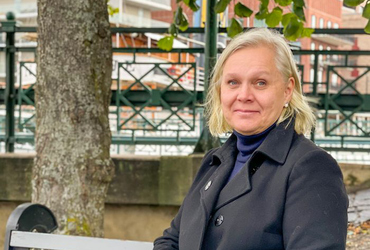 Stadsarkitekten i Norrtälje kommun, Charlotte Köhler, en vit kvinna med blont hår, svart kappa och blå polokrage.